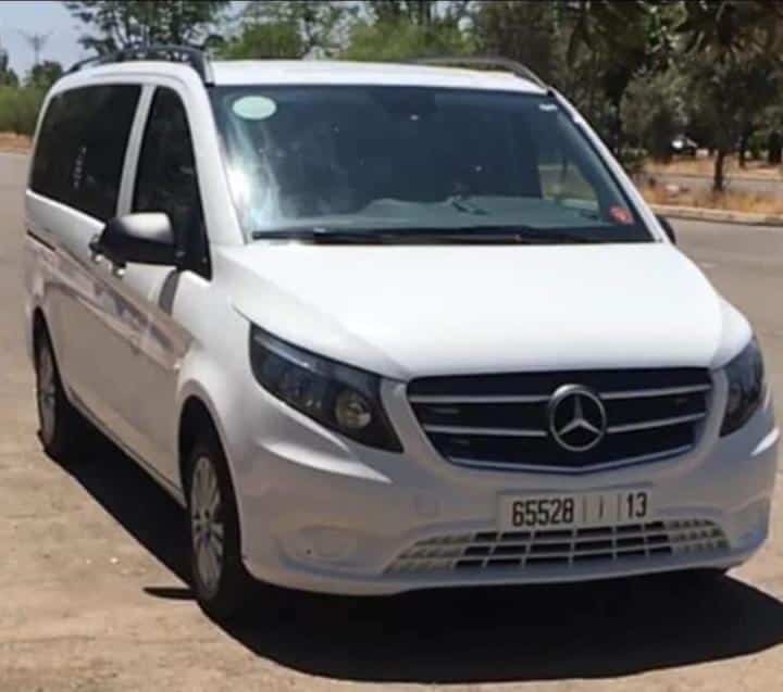 Chauffeur TaxiVert tenant une pancarte d’accueil à l’aéroport du Maroc