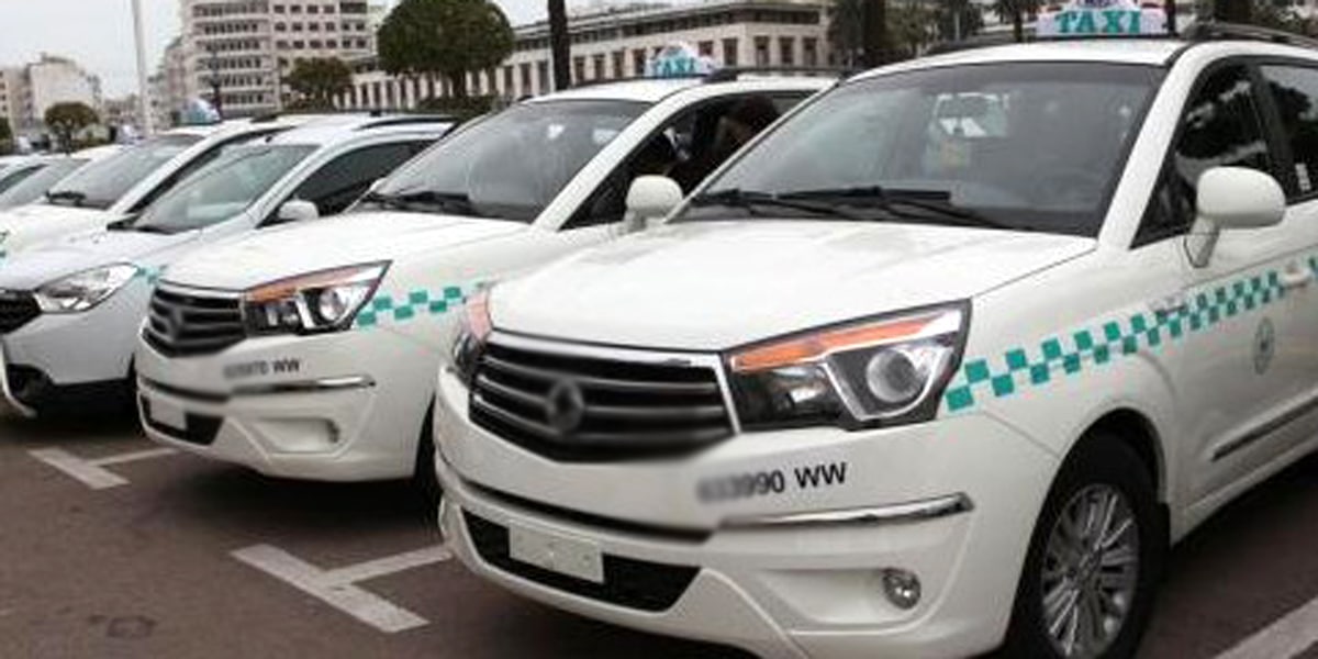 Chauffeur Taxi Vert accueillant un client à l’aéroport de Casablanca